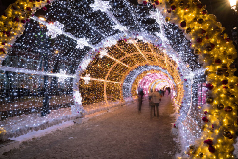 People walking through the New Year and Christmas holidays light tunnel in the city center in Moscow at night